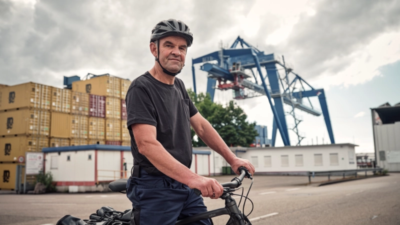 JobRadler steht am Containerhafen und blickt selbstbewusst in die Kamera