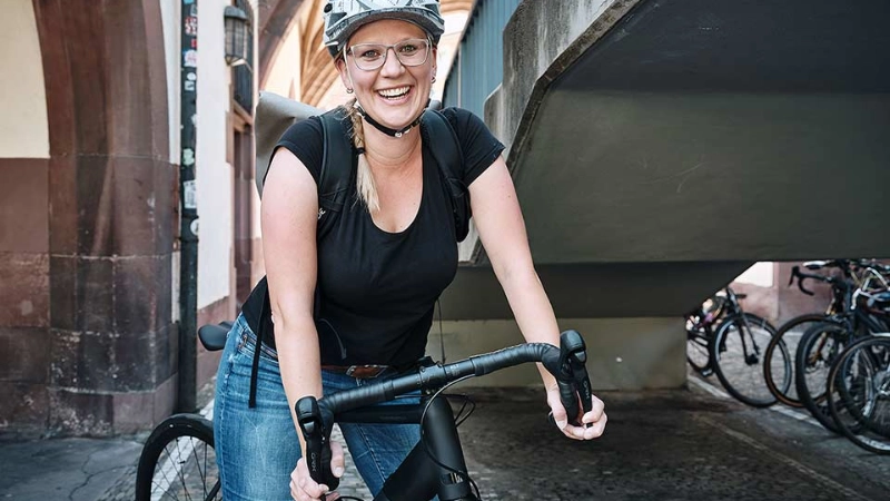 Eine lachende Frau auf ihrem schwarzen Fahrrad Eine lachende Frau auf ihrem schwarzen Fahrrad